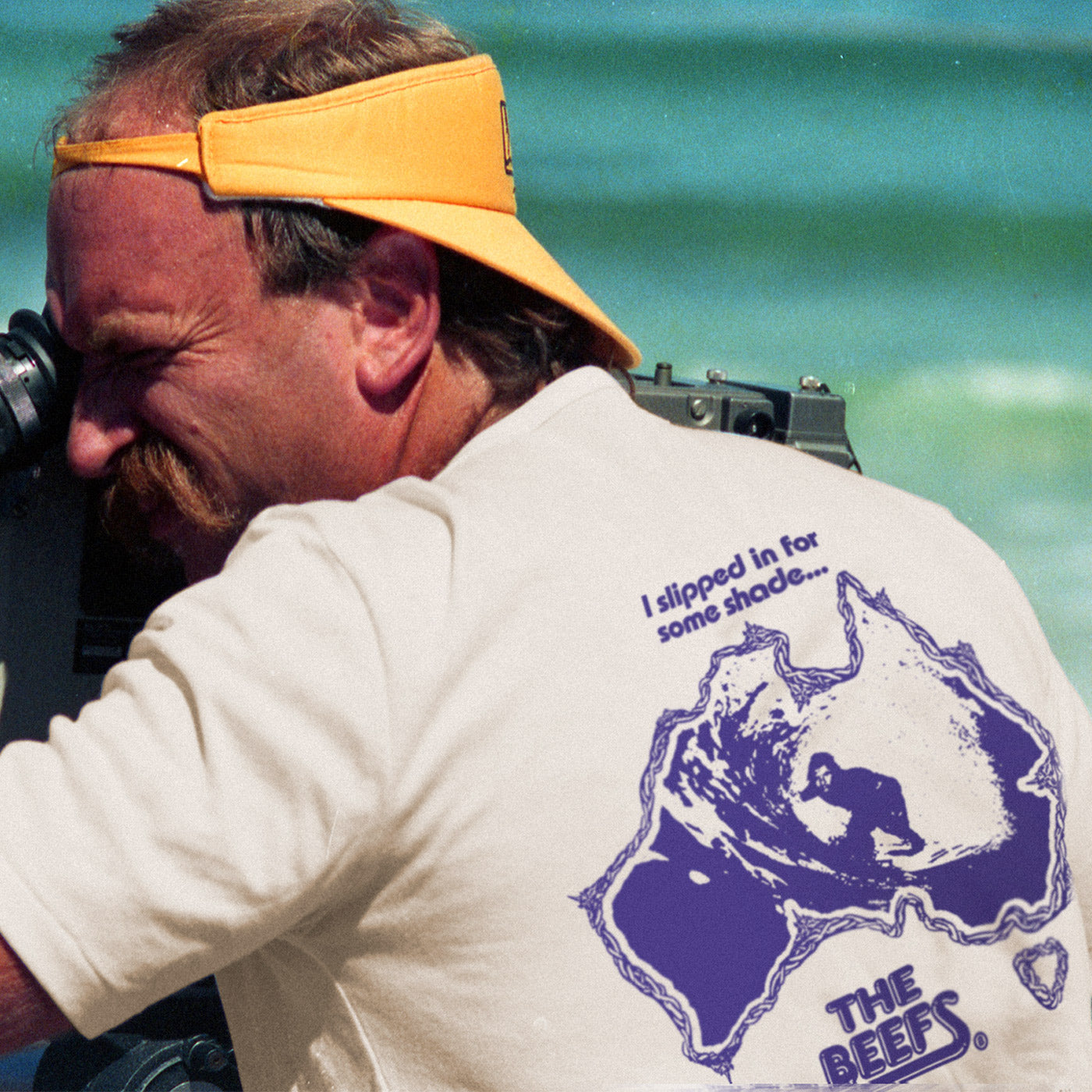 A man in Newcastle, Australia at the beach filming in his Beefs Bazza tee